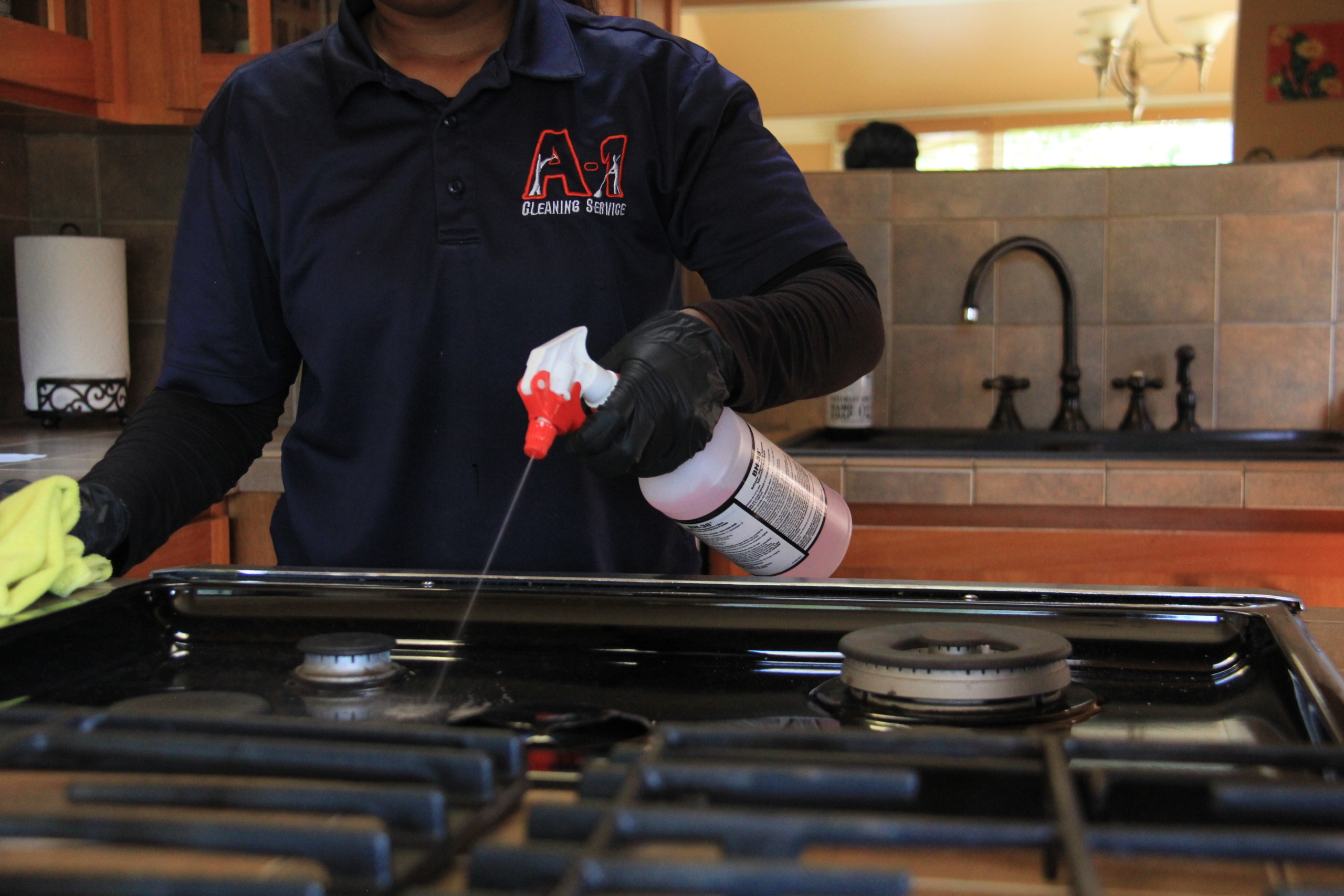 Professional maid service cleaning a kitchen stove in Eureka, CA