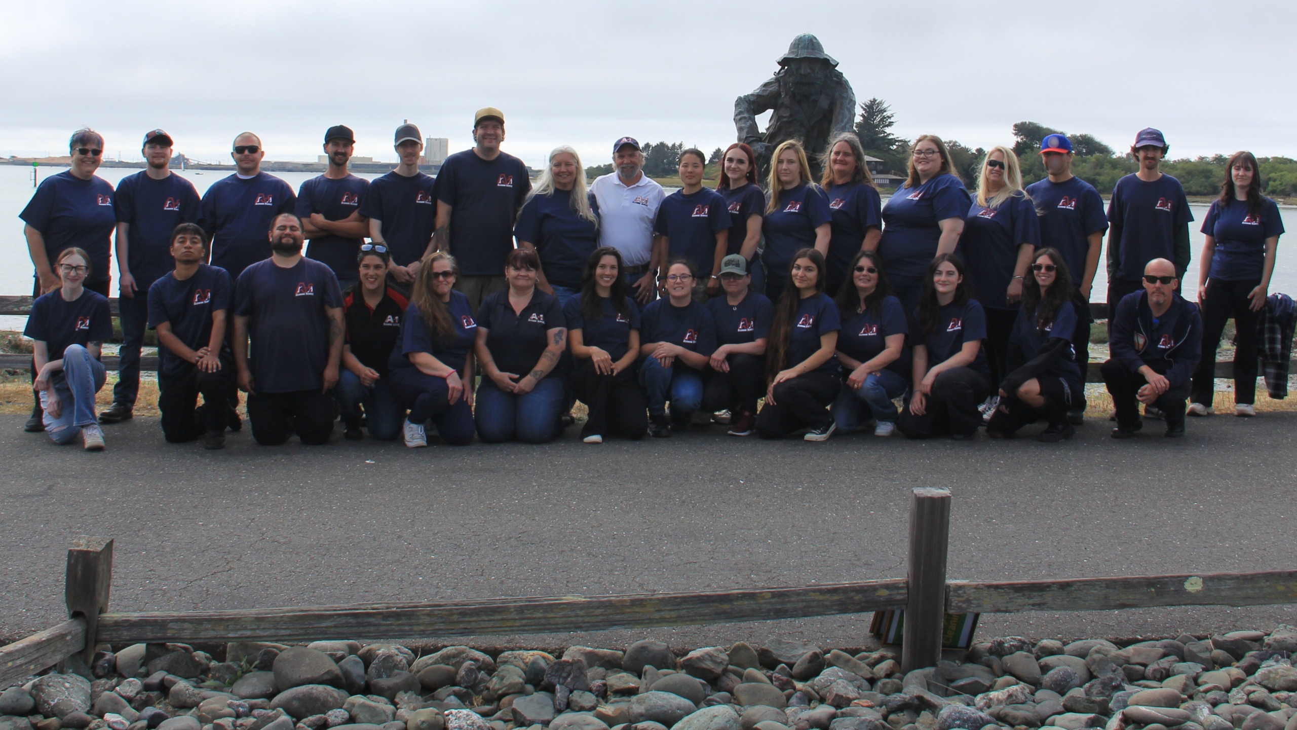 A‑1 Cleaning Service team photo taken along the waterfront in Eureka, CA, with employees wearing matching A‑1 branded shirts gathered in front of a harbor‑side statue.