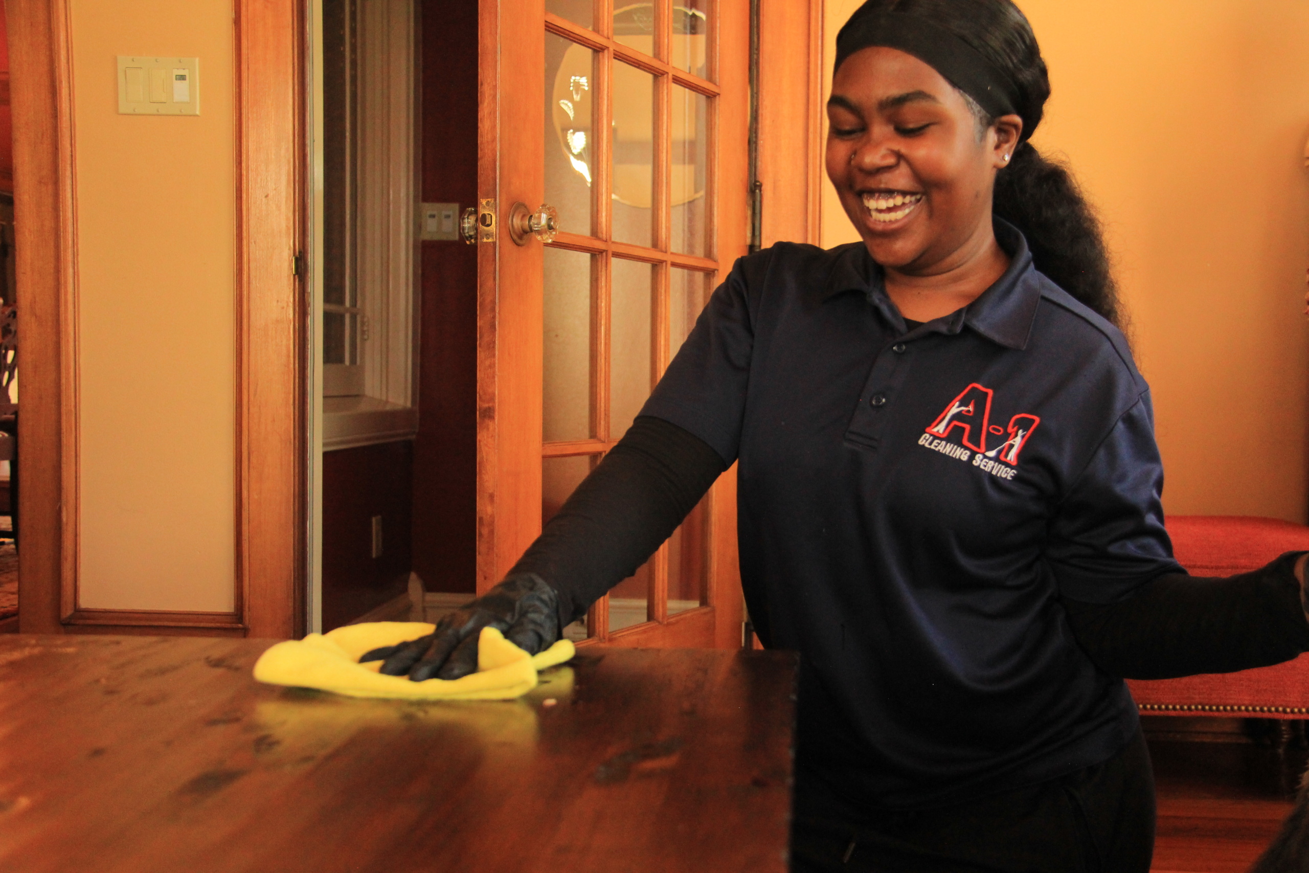 A‑1 Cleaning Service maid team member polishing a wooden table during a residential cleaning in Humboldt County.
