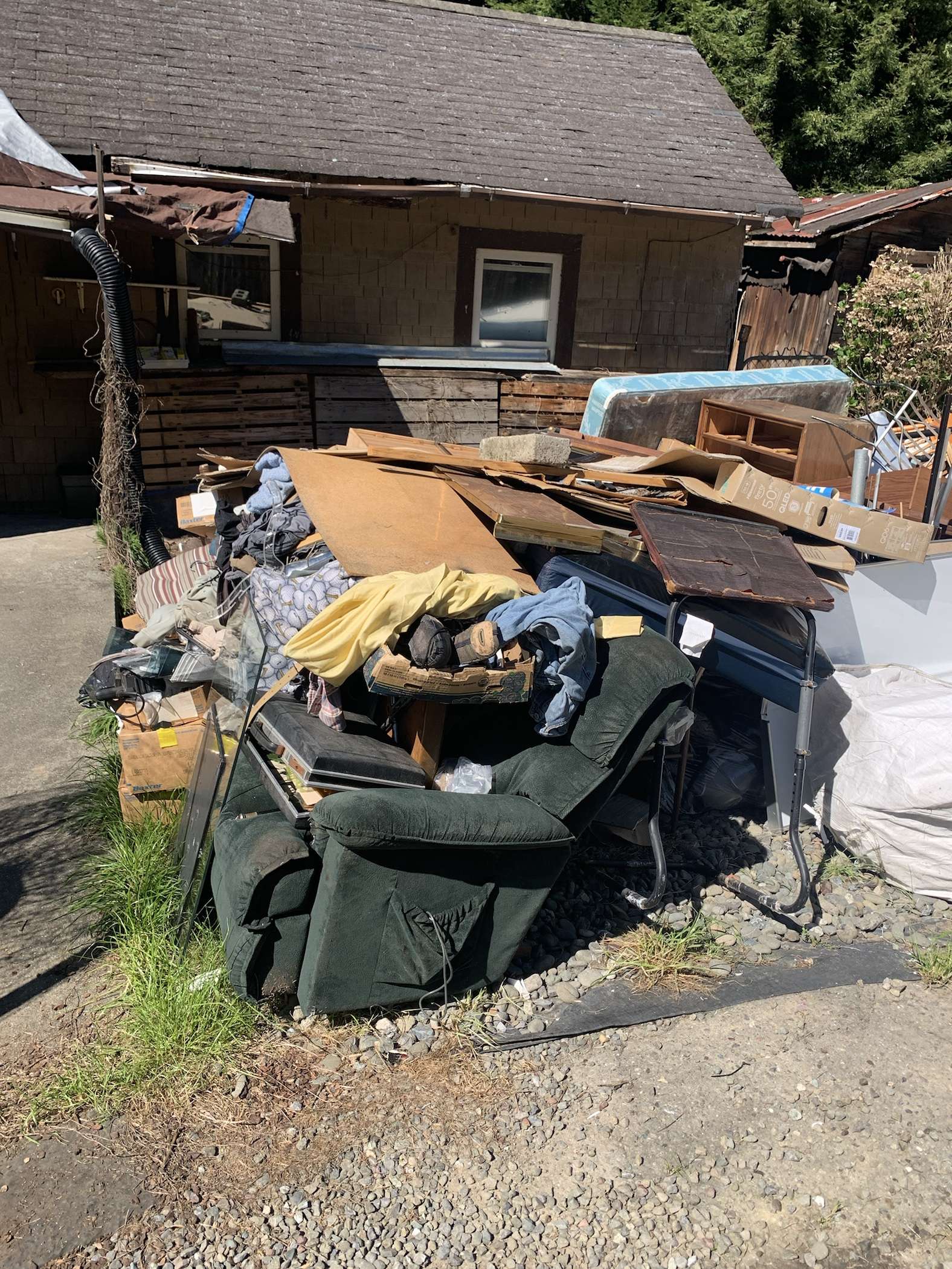 Before junk hauling and hoarder cleanup project in a cluttered outbuilding in Fortuna, CA